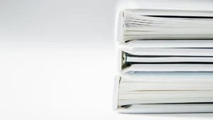 Стопка товстих білих книг з чорними краями на чистому білому тлі