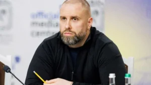 Олег Синєгубов на брифінгу сидить за столом з жовтим олівцем у руках